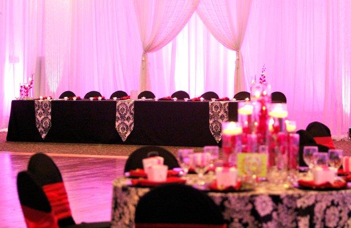 Black White Damask tablecloth and black chair covers with fuchsia napkins and sashes photo by Cindy Skop