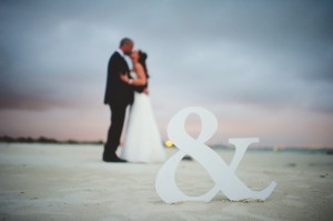 Bride and Groom on Beach with Sign