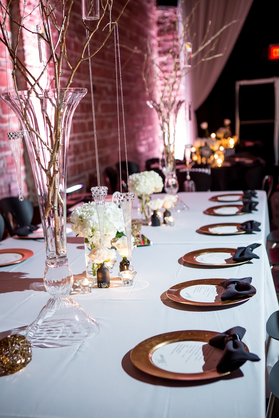 Long Feasting Table with White Wedding Centerpieces and Gold Chargers