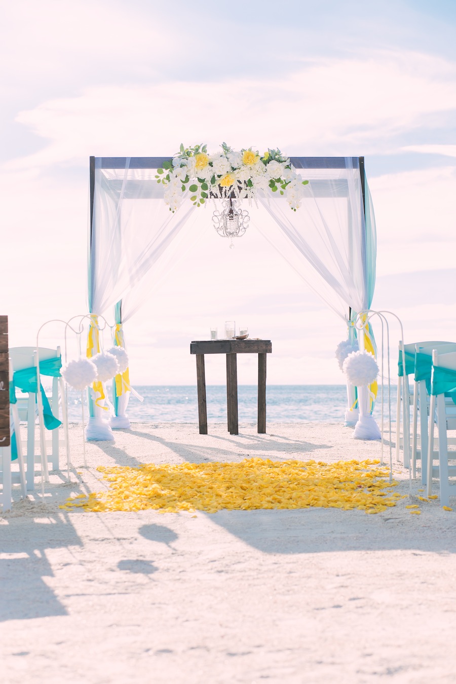 Beach Wedding Ceremony Decor | Wooden Alter with Yellow and White Flowers and Chandelier