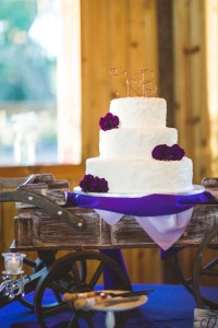 White Wedding Cake with Purple Flora Accents in Rustic Wagon