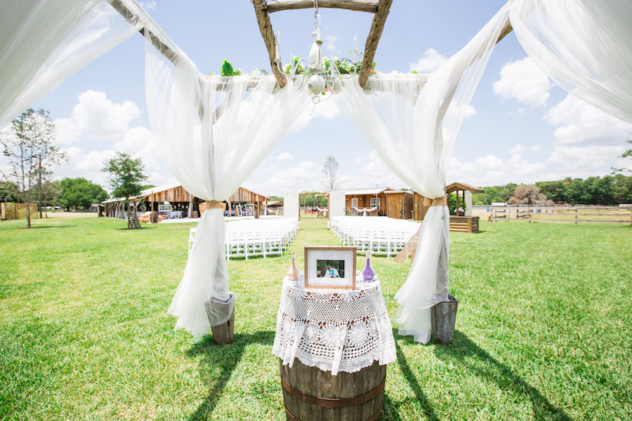 Plant City Outdoor Rustic Wedding Ceremony Altar with Pink and Purple Flowers and Barrel | Plant City Wedding Venue Wishing Well Barn