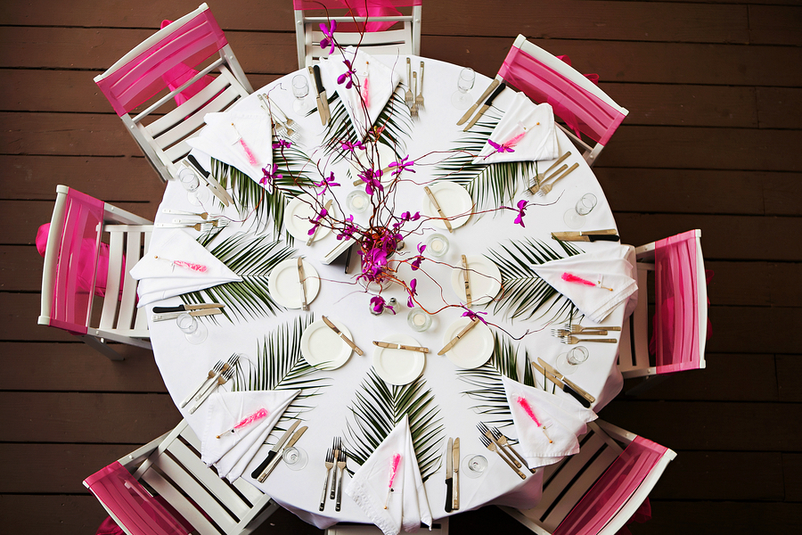 Outdoor Beach Wedding Reception on Patio Deck with Palm Frond Place Settings, and Tall Purple Floral Centerpiece | Clearwater Wedding Venue Hilton Clearwater Beach