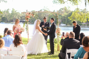 Bride and Groom Exchanging Wedding Vows in Outdoor, Waterfront Wedding Ceremony Site with Wooden Alter | Tampa Bay Wedding Venue The Barn at Crescent Lake at Old McMicky's Farm
