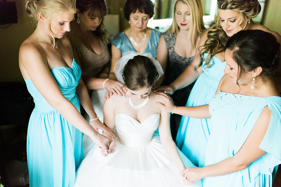 Bride and Bridal Party in Turquoise Blue Bridesmaid Dresses Getting Ready Saying Prayer Before Wedding Ceremony