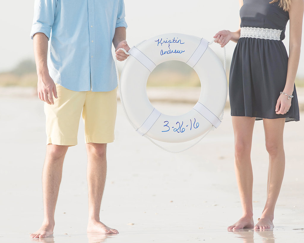 Waterfront, Tampa Engagement Session on the Beach Holding a Life Saver with Wedding Date