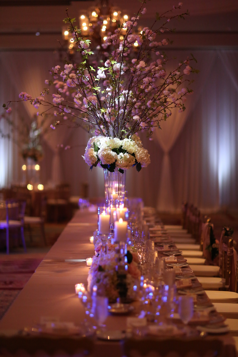 Blush Pink and White Floral Wedding Reception Centerpieces with Cherry Blossom Branches with Candlelight at Long Feasting Table | Sarasota Wedding Venue Ritz Carlton