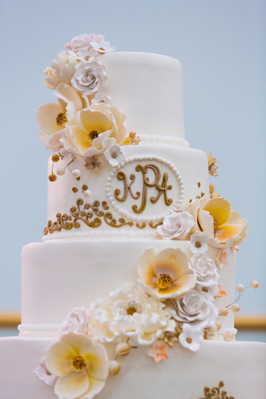 4 Tiered, White Fondant Monogrammed Wedding Cake with White and Gold Edible Flowers | Tampa Wedding Cake Alessi Bakeries