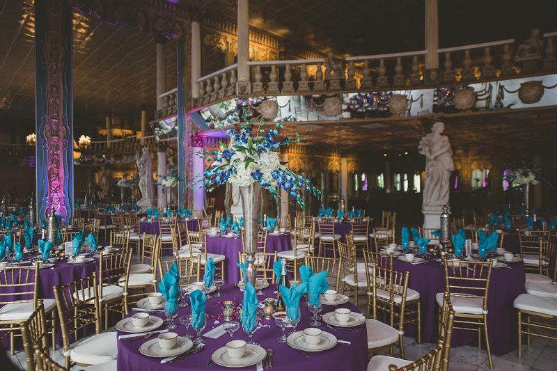 Tall Orchid Wedding Centerpieces with Gold Chiavari Chairs, Teal Blue Napkins and Purple Linens at Clearwater Wedding Venue Kapok Event Pavilion | St. Petersburg Wedding Rentals Rent-All City