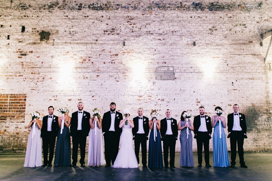Bridal Party Portrait with Black Tuxedos and Assorted Grey Blue Bridesmaids Dresses