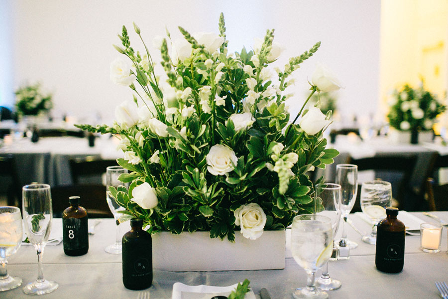 Tampa Wedding Reception Table Decor with Coffee Bottles and White Boxed Centerpieces of Flowers with Greenery