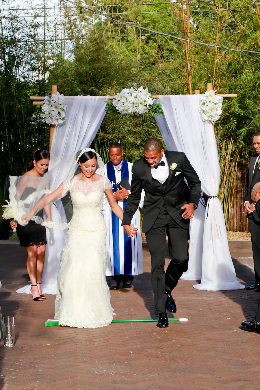 Bride and Groom Jumping Over Broom at St. Petersburg Wedding Ceremony