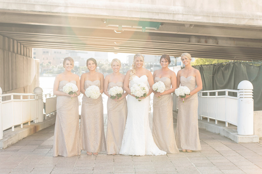 Bride with Bridesmaids in Gold Strapless Dresses with White Bouquets by Wonderland Floral Art | Tampa Bay Bridal Party Wedding Portrait | Wedding Gown from Kleinfelds| Photo by Tampa Bay Wedding Photographer Kristen Marie Photography | Wedding Floral Bouquet by Wonderland Floral Art and Gift Loft