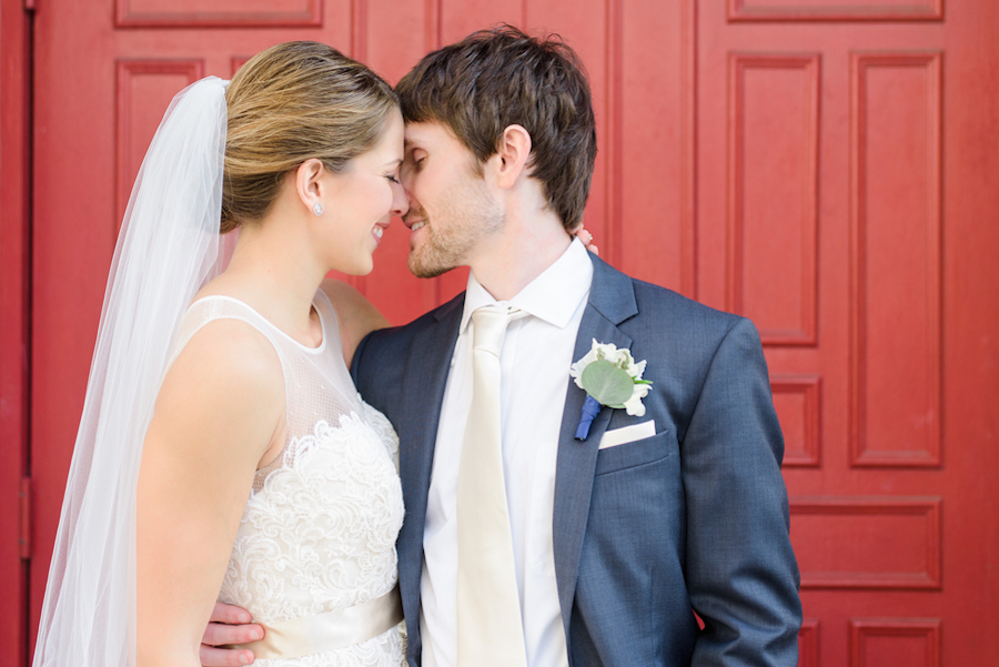 Tampa Bride and Groom Outdoor Wedding Portrait Embracing in Front of Red Door