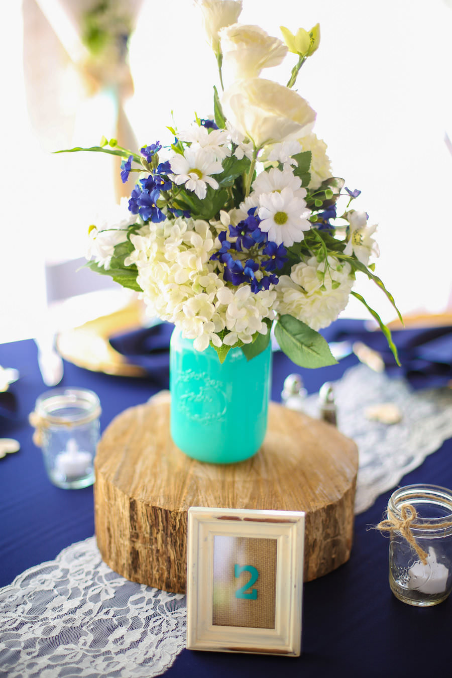 Wedding Reception Decor Details with Blue and White Floral Centerpieces, Mason Jars, and Wooden Slabs