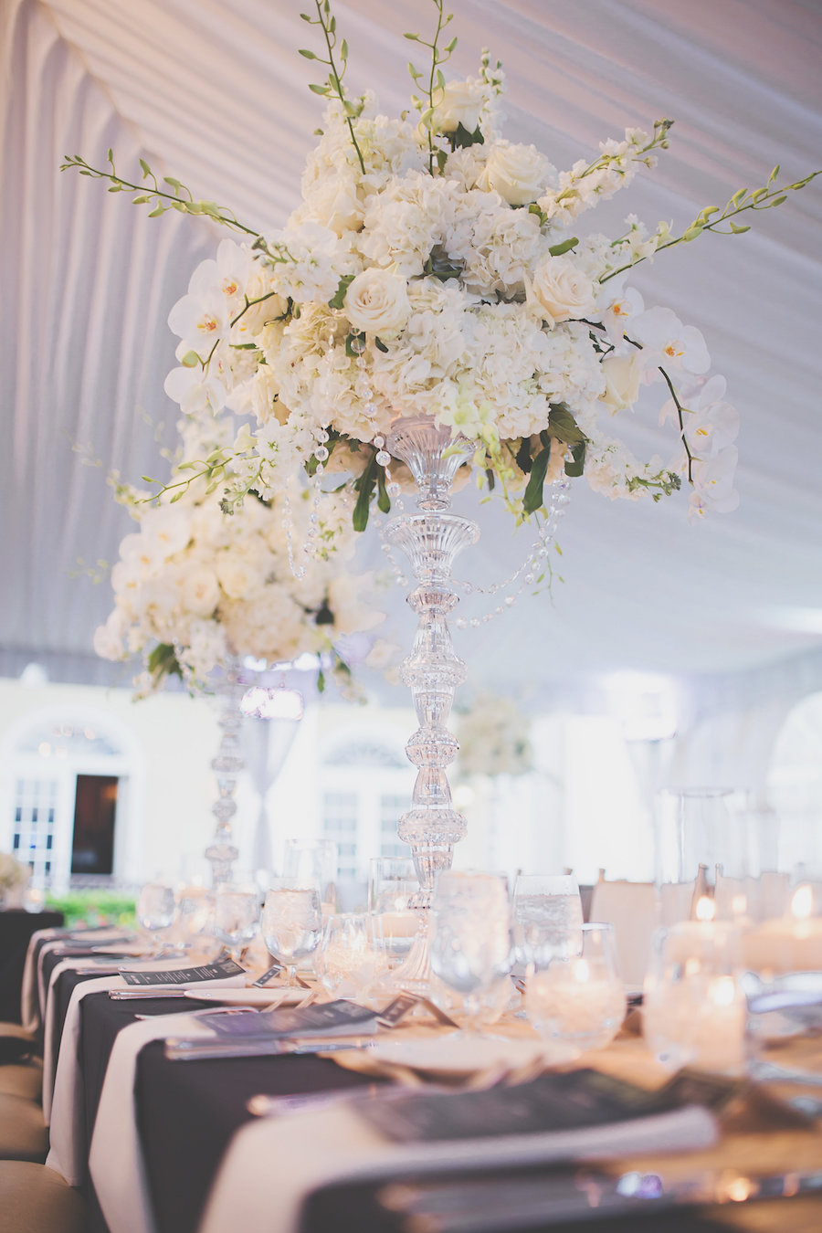 Tall Crystal and Floral Wedding Centerpiece with White Orchids and Roses in Sarasota Outdoor Reception Tent | Sarasota Wedding Planner NK Productions