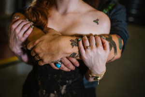 Tattooed Bride and Groom Embracing in Black Wedding Gown