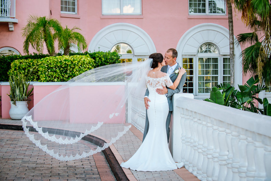 Bride and Groom, Outdoor St. Petersburg Wedding Portrait at the Loews Don CeSar | Off the Shoulder, Lace, White Wedding Gown and Lace Chapel Length Veil