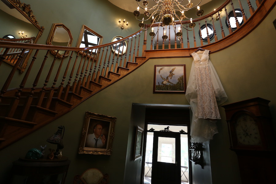 Getting Ready Portrait: Ivory, Lace Bridal Wedding Gown Hanging on Staircase | Lakeland Wedding Venue Rocking H Ranch