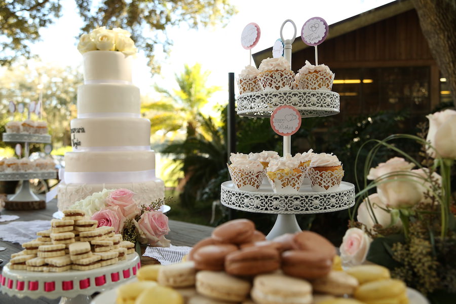 Outrdoor Wedding Reception Dessert Table with Five Tiered White Wedding Cake, Cupcakes, and Macaroons