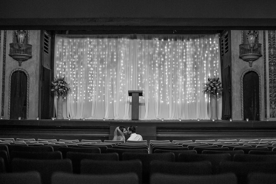Indoor Wedding Ceremony on Stage at Tampa Wedding Venue The Cuban Club | Bride and Groom Kissing Portrait by Wedding Photographer Roohi Photography