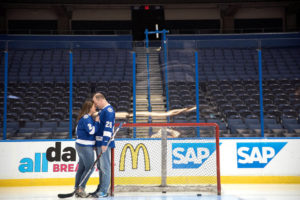 Tampa Lightning Themed Engagement Session at Amalie Arena with Hockey Jerseys, Sticks and Net on Ice | Kristen Marie Photography