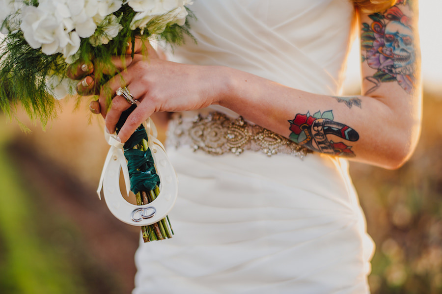 Outdoor, Tattooed Bridal Wedding Portrait in Ivory Stella York Wedding Dress and Ivory Wedding Bouquet with Horse Shoe Decor