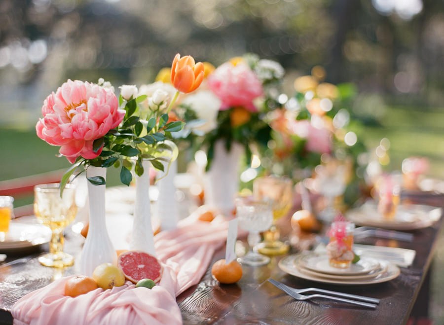 Outdoor Wedding Reception Decor with Vintage, White Vases, Citrus and Orange, Yellow and Pink Wedding Centerpieces on Wooden Farm Table | Tampa Bay Rentals by Tufted Vintage Rentals