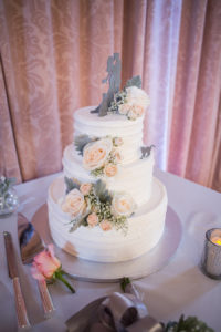 Three Tied Round White Wedding Cake with Blush Pink Roses and Baby's Breath with Bride and Groom Cake Topper