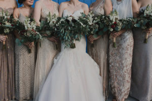 Bridal Party Wedding Portrait with Gold Sequined Mis-Matched Bridesmaids Dresses and Strapless JLM Couture Wedding Dress with Green and Ivory Floral Bouquets