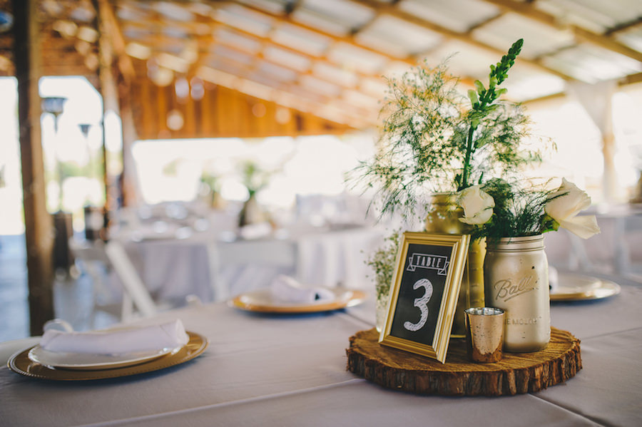 Rustic Barn Wedding Reception Table Decor with Wooden Slab Centerpieces, White Centerpieces, Painted Mason Jars, and Candles