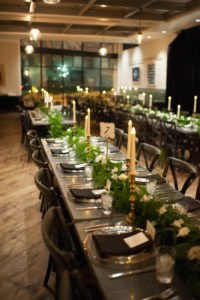 Long Feasting Tables with Candlelight and Elegant/Boho Garland Table Runners/Centerpieces and Wooden Church Chairs | Tampa Wedding Venue The Oxford Exchange