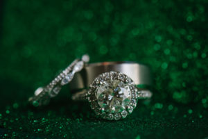 Round Cut Diamond Engagement Ring With Halo and Wedding Bands Portrait on Emerald Green Sparkles