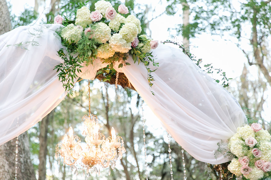 Romantic Outdoor Wedding Ceremony Décor with Tulle, White Hydrangea, Soft Pink Rose and Greenery and Chandelier with Dripping Rhinestones