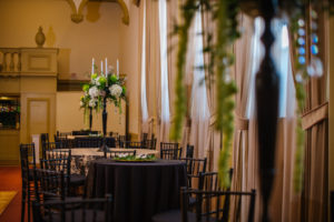 Tall Cascading White and Green Hydrangea and Spider Flower Wedding Centerpieces with White Candles in Dark Bronze Candelabra on Black Tablecloth | Tampa Wedding Florist Apple Blossoms Floral Designs