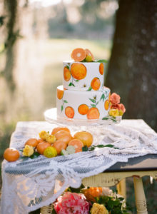 Hand-Painted Wedding Cake with Orange Citrus Cake Topper on Vintage and Lace Table | Tampa Bay Rentals by Tufted Vintage Rentals