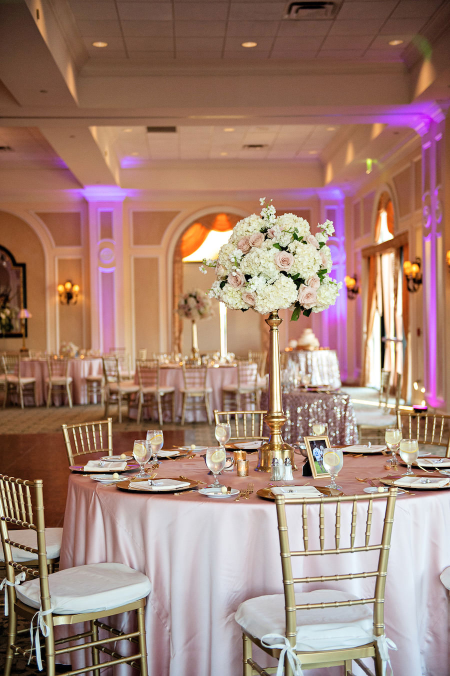 Tall White Hydrangea and Blush Pink Rose Centerpiece Flowers in Gold Vase with Pink Specialty Linens and Gold Chiavari Chairs | Wedding Reception Decor