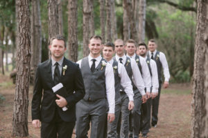 Groom and Groomsmen in Matching Grey Vests and Slacks Walking Down the Aisle Outdoor Wedding Portrait | Rustic Outdoor Wedding in Tampa