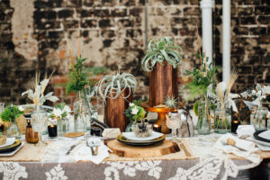 Tampa Nature Inspired Wedding Reception Table Decor with Brass, Greenery Centerpieces, Crystal Goblets, Wooden Place Settings, and Doily TableCloth