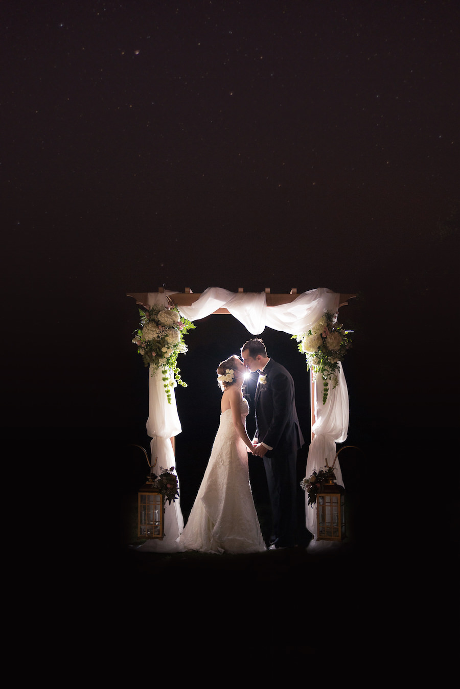 Bride and Groom Nighttime Wedding Portrait Under Ceremony Arch with Draping | Tampa Wedding Floral Designer Northside Florist | Tampa Golf Course Wedding Venue Hunter's Green Country Club