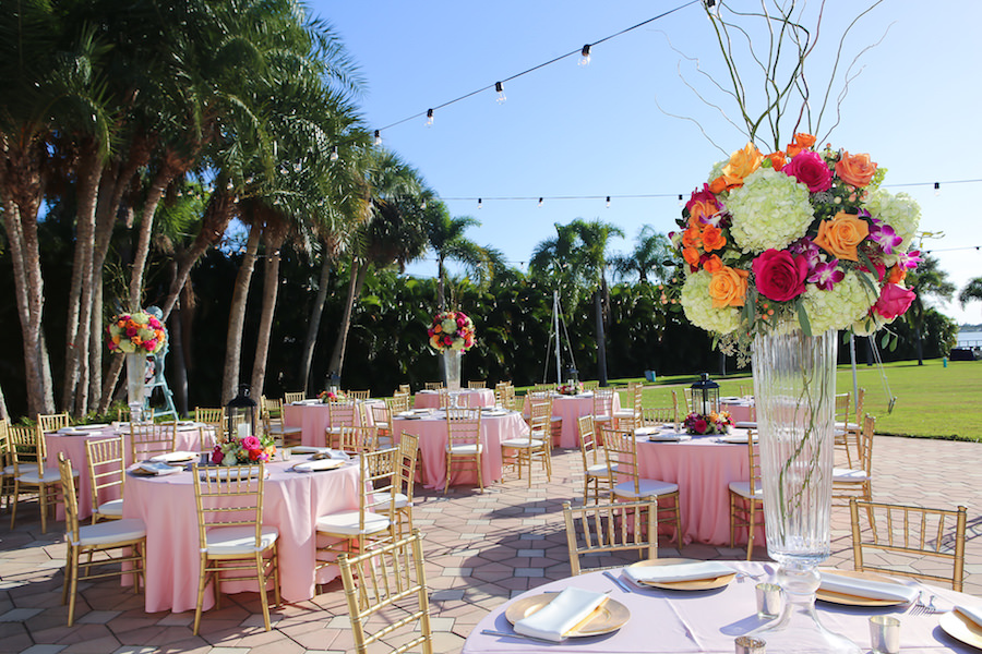 Outdoor St Petersburg Wedding Reception Décor with Gold Chiavari Chairs, Pink Linens and Orange, Bright Pink and Fuchsia Tall Floral Centerpieces with Lanterns and Market Twinkle Lights | Exquisite Events Wedding Planning