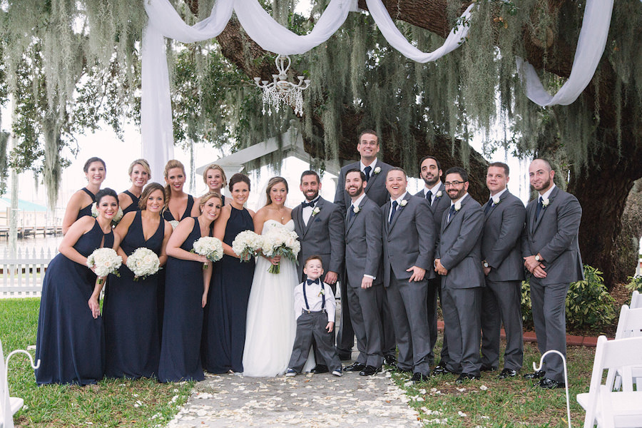Outdoor, Palmetto Bridal Party Portrait with Navy Blue Bridesmaids Dresses and Gray Groomsmen Suits | Tampa Bridesmaids Shop Bella Bridesmaids | Bradenton Wedding Florist Iza's Flowers