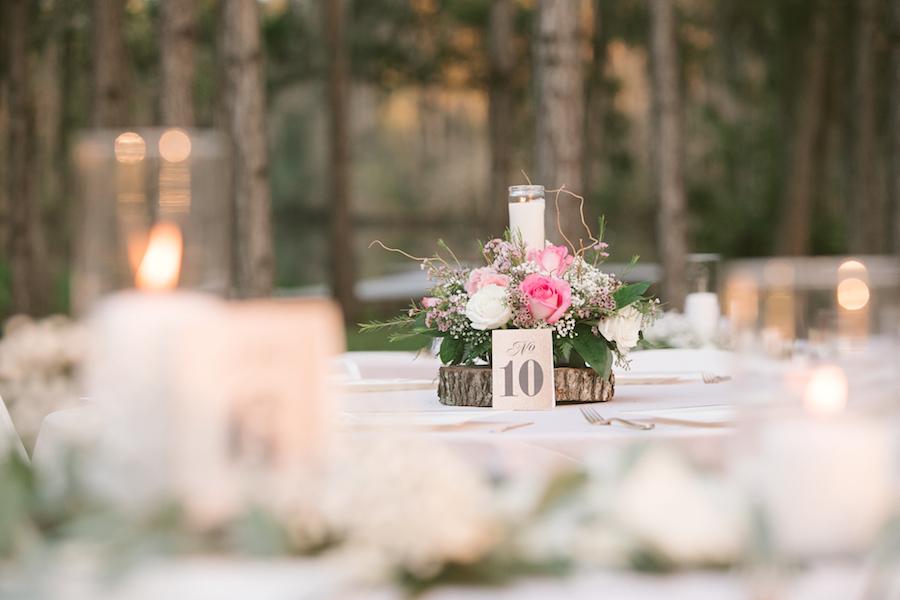 Outdoor Rustic Wedding Reception Centerpieces with Pink, Ivory and White Roses, Baby’s Breath and Greenery on Wood Rounds with Light Pink Tablecloth | Tampa Bay Wedding Floral Designer Northside Florist
