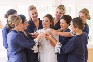 Bride and Bridesmaids Wedding Portrait Cheers with Champagne Glasses in Matching Robes