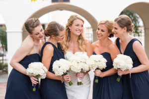 Bridal Party Portrait with Bride an Bridesmaids in Navy Bridesmaids Dresses and White Floral Wedding Bouquets
