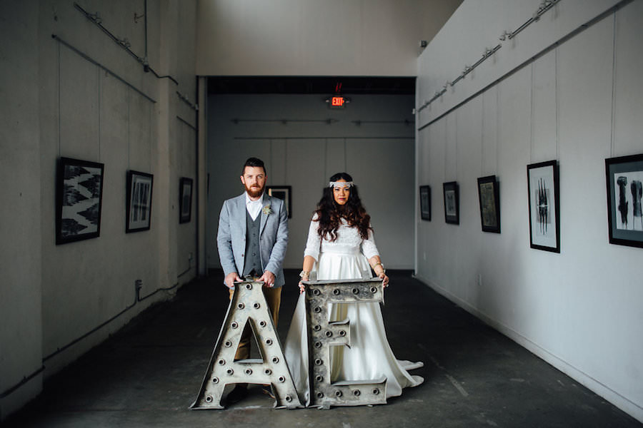 Tampa Bohemian-Nature Inspired Bride and Groom Wedding Portrait with A and E Vintage Initial Signs and Grey Suit and Lace, Wedding Dress and Headband | Isabel O'Neil Bridal Collection