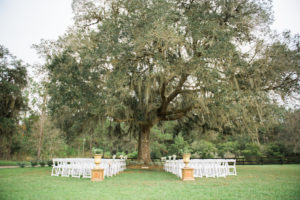 Outdoor Shabby Chic Rustic Wedding Ceremony Under Spanish Moss Tree with White Resin Folding Chairs | Tampa Bay Wedding Photographer Kera Photography | Dade City Wedding Venue Barrington Hill Farm