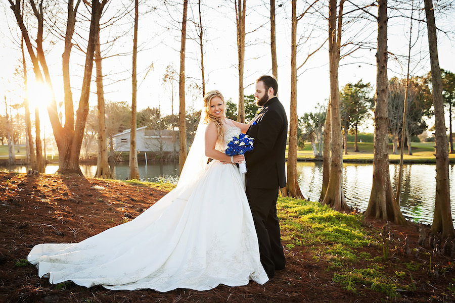 Bride and Groom Wedding Portrait in Ivory Wedding Dress with Cathedral Train and Veil with Royal Blue Roses and Ivory Lily Bouquet | Countryside Country Club Wedding Venue | Limelight Photography Wedding Photographer