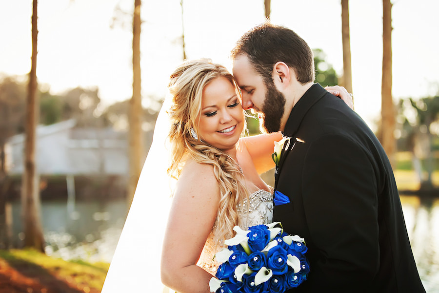 Clearwater Bride and Groom Wedding Portrait in Traditional Black Tuxedo and Ivory Minerva’s Bridal Wedding Dress with Royal Blue Roses and Ivory Lilies | Countryside Country Club Wedding Venue | Limelight Photography Wedding Photographer