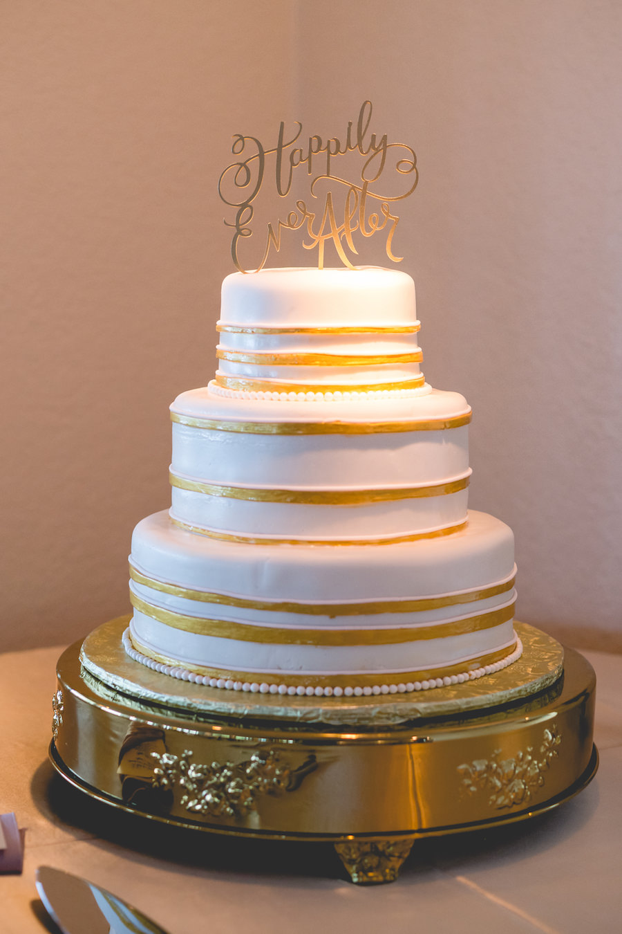 3 Tiered, White, Round Wedding Cake with Gold Accents and Happily Ever After Cake Topper